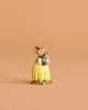 The Wee Forest Folk Tiny Collectible - Bluebird of Happiness features a small, hand-sculpted rabbit figurine in a yellow dress with painted flowers and a flower crown, standing on a matching base.