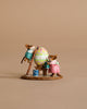 Two Wee Forest Folk Tiny Collectible mice in vibrant outfits paint a giant Easter egg—one on a ladder, one with a paint can—set on a table against a beige background. "Colossal Easter Coloring" is perfect for miniature fans.