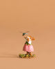 The Wee Forest Folk Tiny Collectible - Pretty Perch in Pink features a hand sculpted mouse in a pink dress standing on grass and holding a dragonfly, set against a plain light brown background.