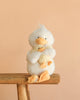 Bukowski - Dougie & Mama Duck, two fluffy white plush ducks with orange beaks and feet, sit together on a stool against a peach background, creating a cute and cozy scene perfect for snuggles.