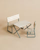 A miniature white and teal Maileg garden set including a park bench and matching chair, constructed from FSC certified wood, set against a plain beige background.