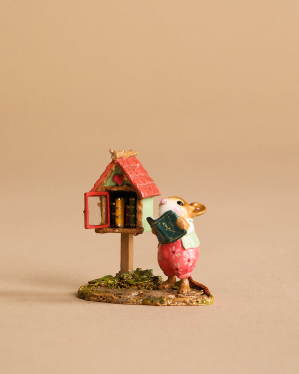 The Wee Forest Folk Tiny Collectible - Little Library in Pink features a mouse in a pink dress holding a book next to a red-roofed miniature library. Hand sculpted in the USA, this is not a toy. Set against a neutral background.