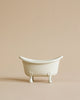 A Maileg Bathroom Set sits centered on a beige background, evoking the charm of a miniature bathroom, with ample empty space above and around it.