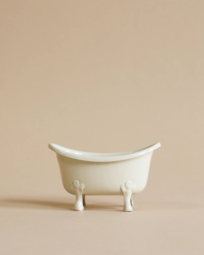 A Maileg Bathroom Set sits centered on a beige background, evoking the charm of a miniature bathroom, with ample empty space above and around it.