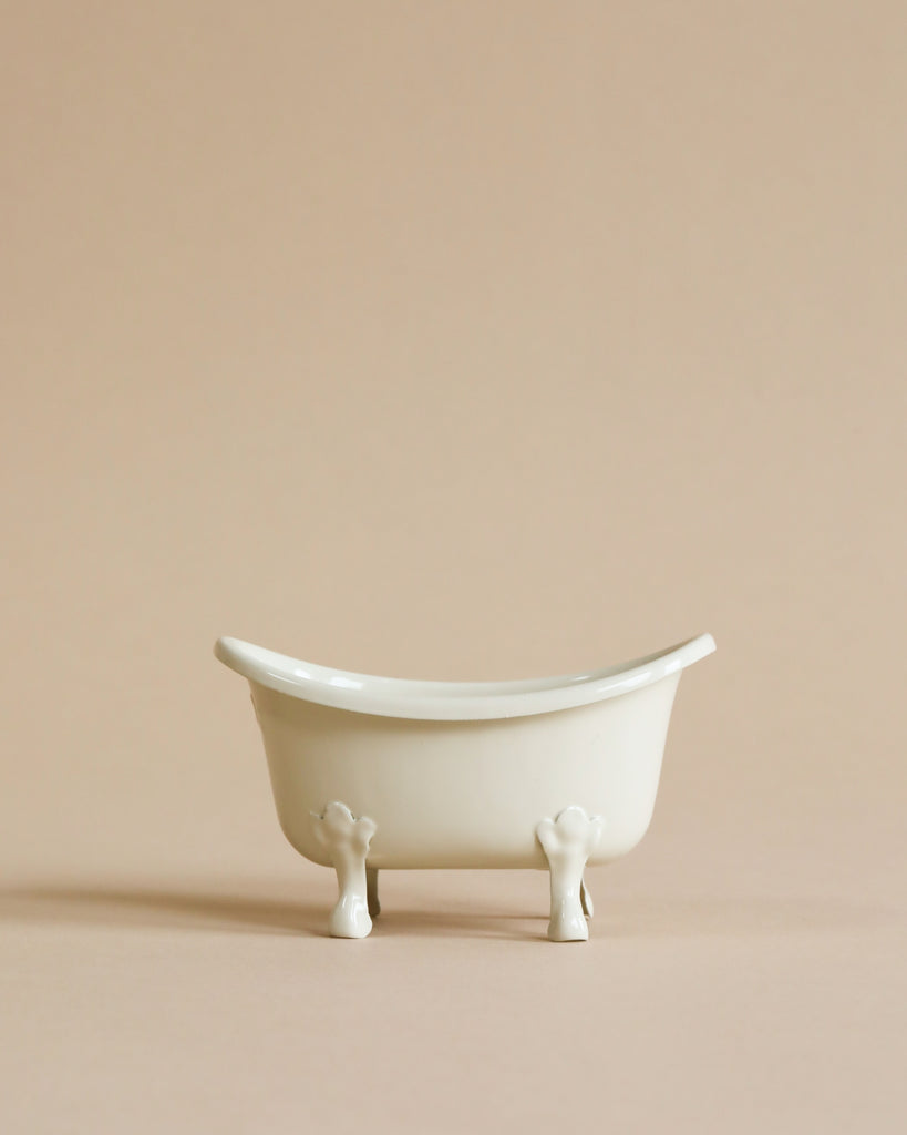 A small, white Maileg Bathtub (Miniature) against a beige background. The empty tub is centered in the image, showcasing its smooth, minimalist design and classic curved edges.