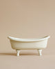 A miniature ceramic Maileg Mini Bathtub with elegant white claw feet, displayed against a soft beige background.