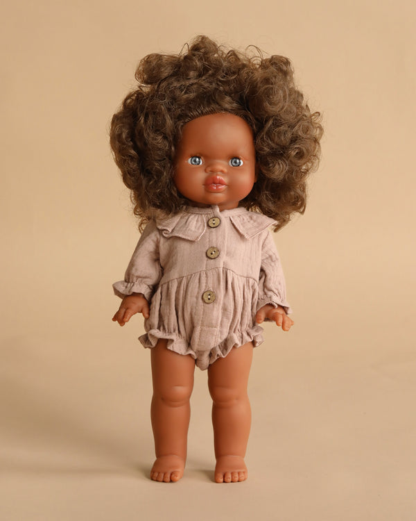 The Minikane Standing Doll (14") – Charlie with Clothing features a brown-skinned, anatomically correct doll with curly brown hair in a beige romper with large buttons, shown standing upright against a plain beige background.