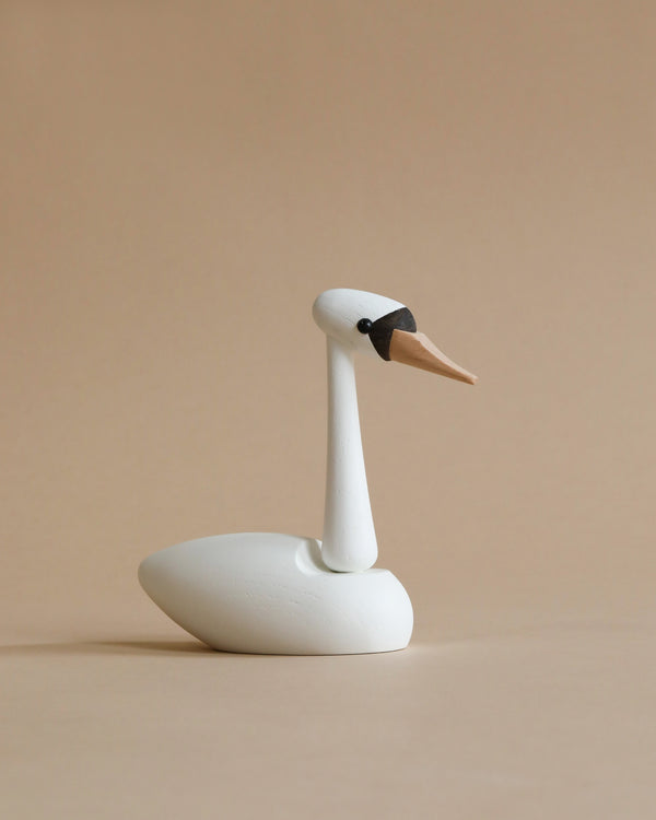 A minimalistic white Spring Copenhagen The Cygnet figurine with a long neck and pointed beak, set against a plain beige background.