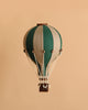 The Hot Air Balloon - Light Brown / Green is a small, handmade model featuring green and beige stripes and a woven basket—ideal as a charming decoration for a child’s room.