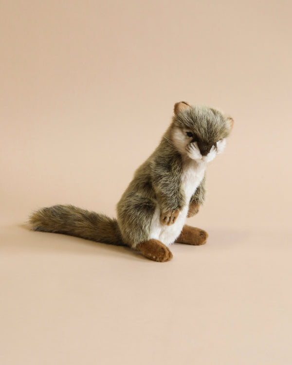 A plush toy of a Standing Squirrel Stuffed Animal with gray fur, a white chest, and a fluffy tail, featuring realistic features in a sitting pose against a light beige background.