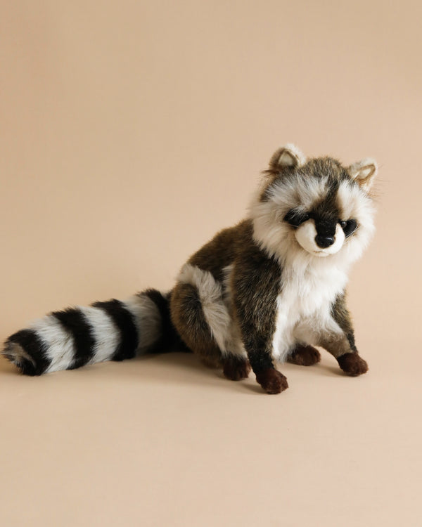 A Raccoon Stuffed Animal with realistic fur patterns and colors, sitting against a soft beige background. The toy features realistic features including a detailed face and a long striped tail.