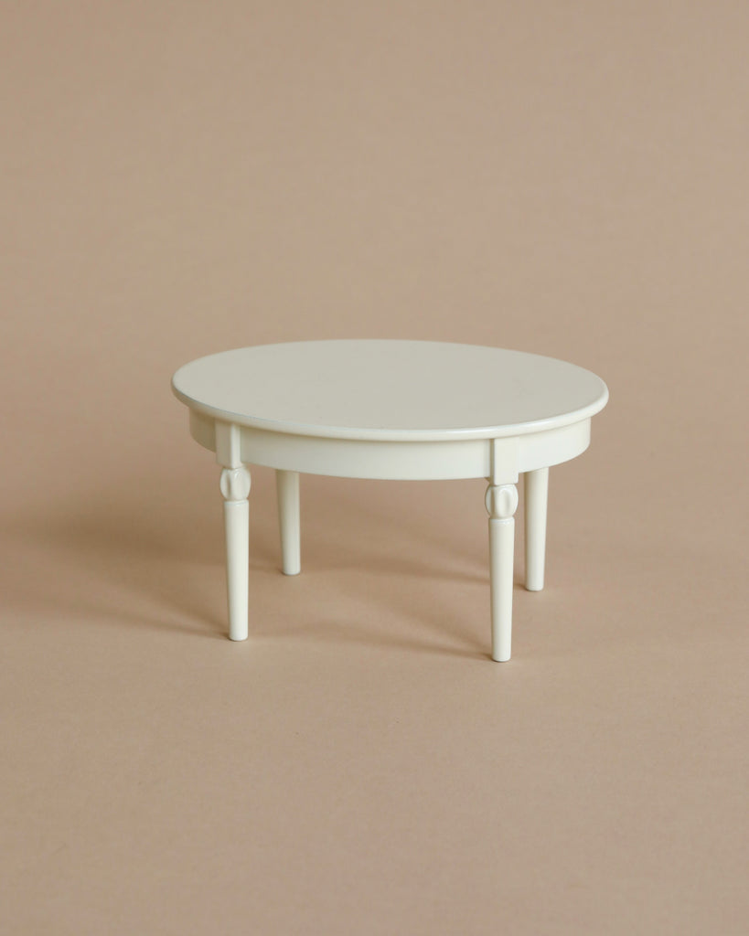 The Maileg LouiMax and Stella Cozy Kitchen Set features a small, white, round table with four legs on a light beige background—its minimal design makes it ideal for Maileg mouse furniture or any Maileg miniature set.
