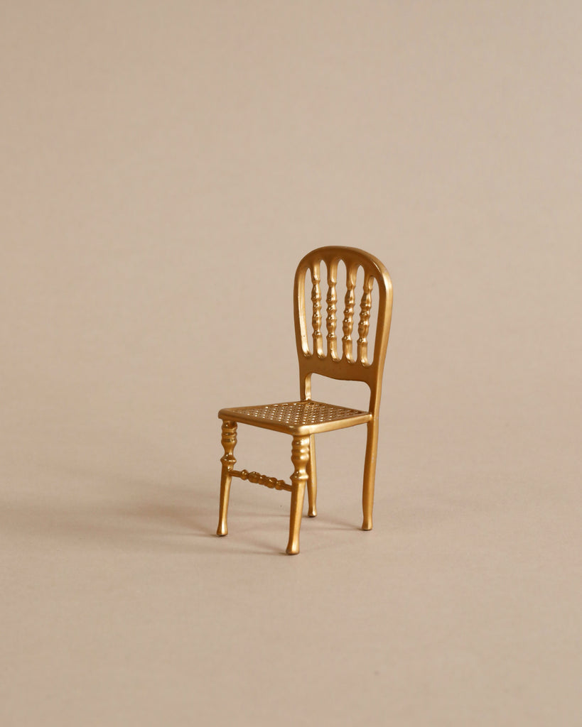 Metal gold chair with beige background. 