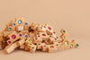 A set of 40 Bauspiel Colored Stair Blocks in various geometric shapes, each adorned with colorful, shiny gem-like accents, displayed against a plain beige background.