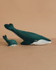 The Bumbu Handmade Wooden Blue Whale Family Set features two sustainably crafted, dark teal wooden whales—one large and one small—with white underbellies, placed side by side for inviting Montessori play.