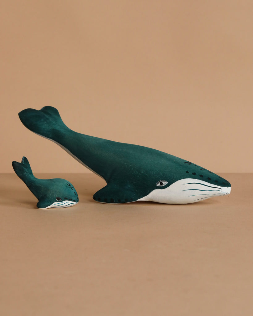 The Bumbu Handmade Wooden Under the Sea Set features two wooden whale figurines, large and small, painted dark teal with white undersides—perfect ocean animals for Waldorf-inspired play or decor.