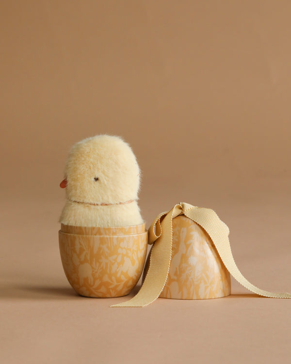 The Maileg Easter Egg with Mini Chick features a fluffy yellow plush inside a floral egg container with a matching ribbon lid—perfect as an Easter gift set.