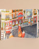 Illustration in Ruby The Red Electric Bus Book depicting a vibrant street scene with colorful buildings, a red double-decker bus, bicycles, and stylized characters. Signs read "underground" and "moplanet.