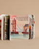 A deck of illustrated playing cards featuring famous London landmarks, including greener transportation like Ruby The Red Electric Bus and Tower Bridge, spread out on a beige background.