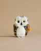 A Steiff Wittie Owl plush toy with large yellow eyes, white and brown cuddly soft woven fur, and a visible "Button in Ear" tag, standing against a plain beige background.