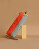 The Sticky Lemon Pencil Case | Color Blocking | Lifebuoy Orange + Shark Grey, made from recycled PET bottles, stands upright next to two colored pencils on a beige background, highlighting its orange and gray color block design.