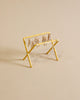 The Maileg Laundry Room Set features a small yellow drying rack with miniature clothespins, displayed on a beige surface for a simple, minimalistic look.