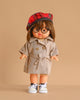 The Minikane Standing Doll (14") - Chléa With Clothing features brown hair, round glasses, and a red plaid beret, dressed in a beige trench coat and white sneakers. Stands against a beige background. Made in Spain.