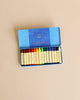 A box of the Easter Basket Set crayons arranged neatly in a row. The box is blue with a logo on the lid, set against a plain beige background.