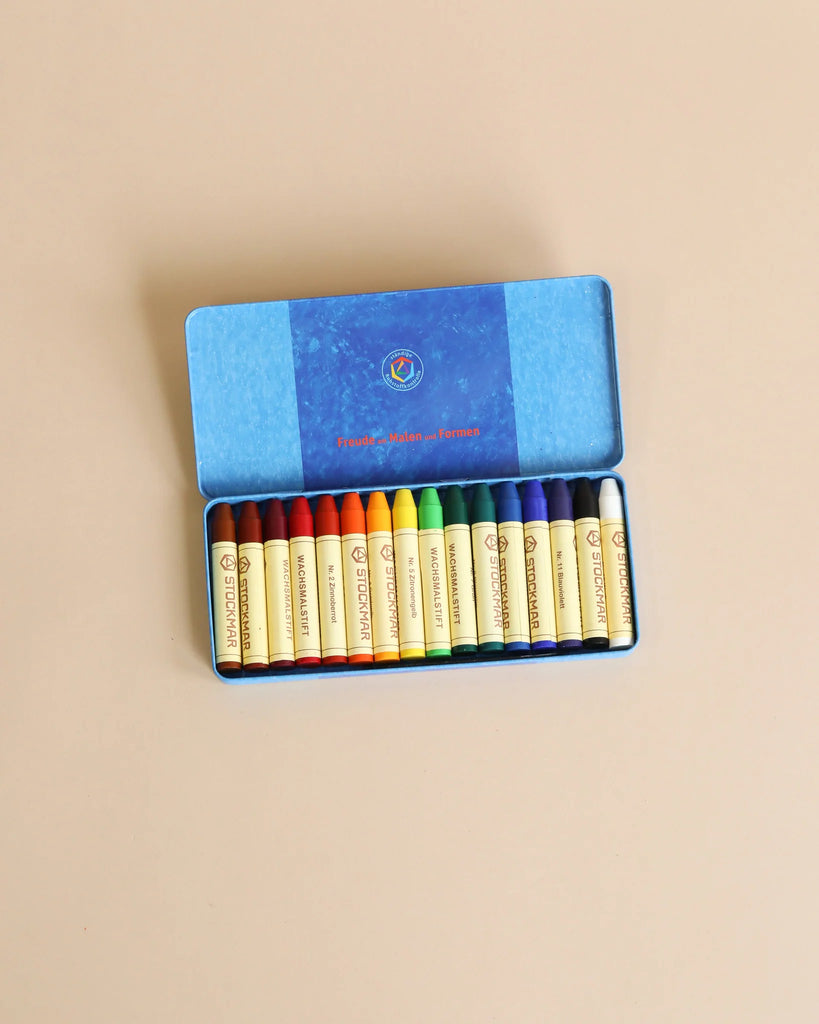 A box of the Easter Basket Set crayons arranged neatly in a row. The box is blue with a logo on the lid, set against a plain beige background.