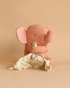 A soft, pink Maileg Lullaby Friends - Elephant - Old Rose (Plays Music) sits against a beige background. The elephant, with large, pink polka-dotted ears, hugs a white, polka-dotted blanket. Nearby, a baby bunny toy adds to the charm of the cozy scene. The toy's small tail with a tuft completes this delightful tableau.