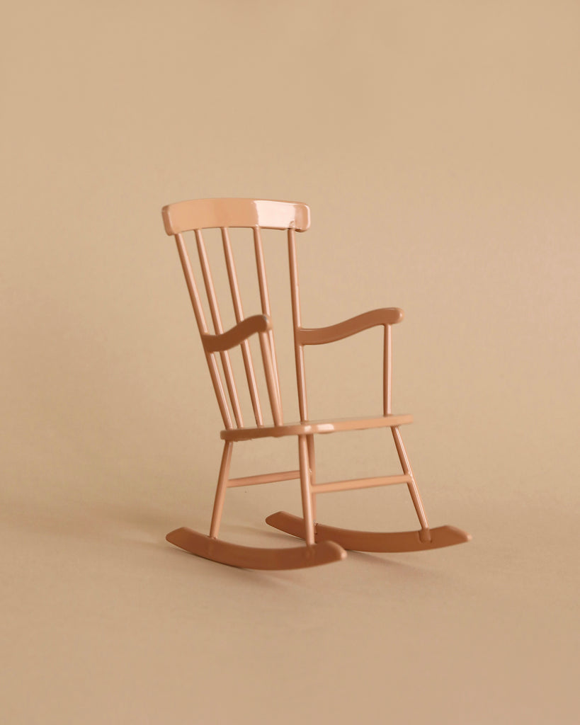 The Maileg Little Rabbit’s Rocking Chair Set features a light brown wooden chair with vertical backrest slats and curved rockers, set against a beige background—ideal for a Maileg Rabbit or Miniature.