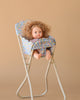 The Konges Sloejd High Chair - Rose Flower features a curly-haired doll in a floral outfit seated in the foldable chair against a plain beige background.