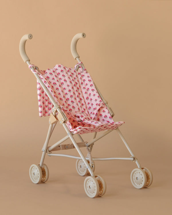 The Konges Sloejd Doll Stroller - Rosie Rose features a pink floral seat and white frame—compact, lightweight, and perfect for playtime adventures.