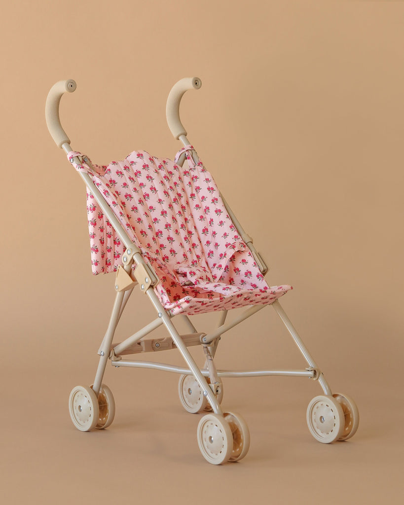 The Konges Sloejd Doll Stroller - Rosie Rose features a pink floral seat and white frame—compact, lightweight, and perfect for playtime adventures.