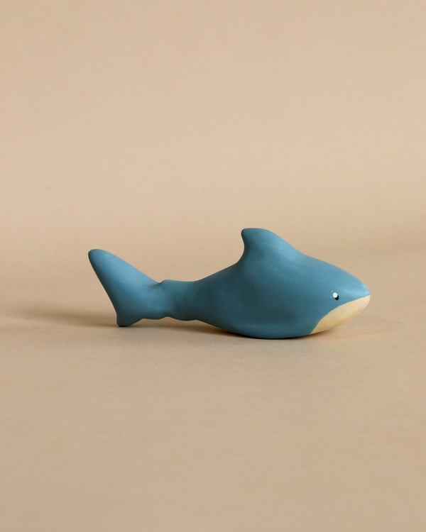 A small, ceramic figurine of a Handmade Wooden Shark with a light beige underside, handmade in Serbia, displayed against a plain beige background.