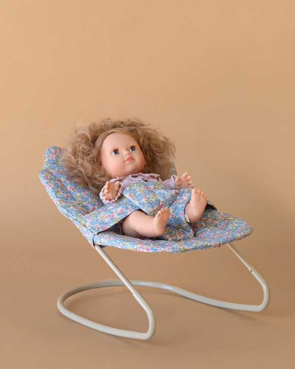 The Konges Sloejd Doll Bouncer - Rose Flower features a floral-patterned seat and sturdy metal frame—perfect for displaying your doll in style and a charming upgrade to any doll accessory collection.