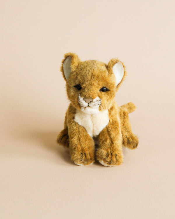 A hand-sewn Lion Cub Stuffed Animal with a smiling face, standing upright on a light beige background. Its fur is golden-brown with a lighter chest and facial fur, crafted from high-quality plush materials.