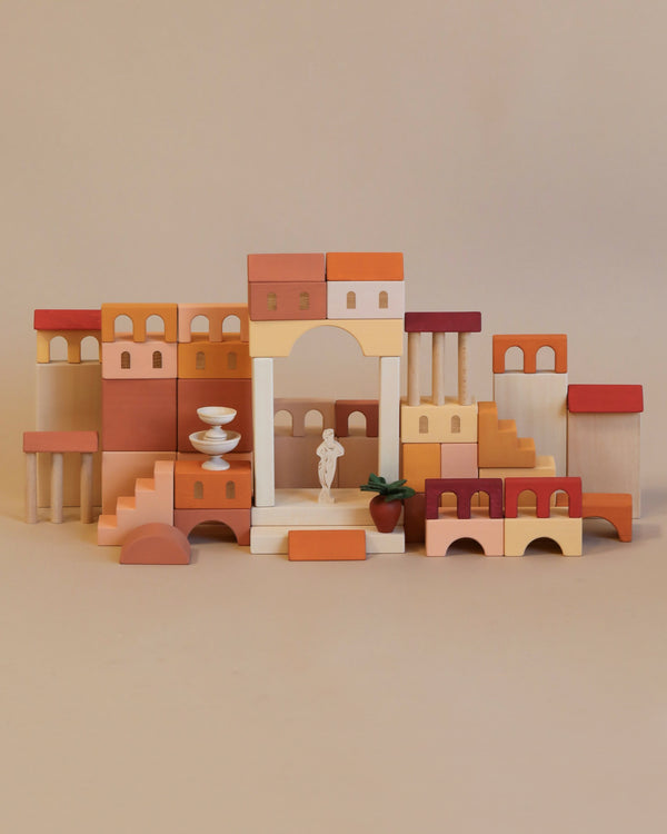 A Sabo Concept Italian Courtyard Blocks set arranged to resemble a miniature Italian courtyard with buildings, archways, and steps in various shades of brown and red, featuring a small statue in the center.