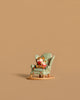 The Wee Forest Folk Tiny Collectible - Sharing A Story (Not a Toy) features a miniature fox figurine seated in a green floral armchair, displayed on a tan surface with a plain tan background.