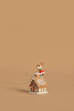 The Wee Forest Folk Tiny Collectible - Santa's Gingerbread House features a small reindeer in a red scarf on the festive roof, handcrafted by New England artisans, and shown against a plain light brown background with ample empty space.