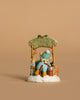 The Wee Forest Folk Tiny Collectible, "Hot Cocoa Comin' Up!" (Not a Toy), features a hand-sculpted mouse child in winter attire on a snowy bench under holly with a lantern and festive accents against a plain beige background.