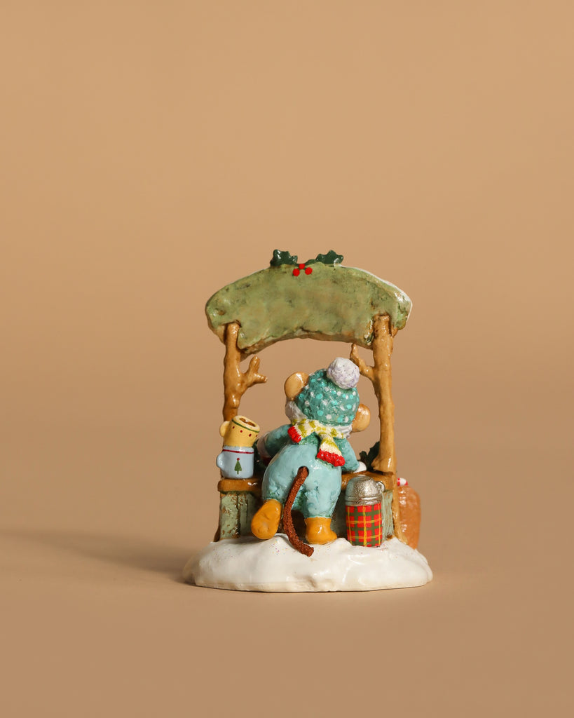 The Wee Forest Folk Tiny Collectible, "Hot Cocoa Comin' Up!" (Not a Toy), features a hand-sculpted mouse child in winter attire on a snowy bench under holly with a lantern and festive accents against a plain beige background.