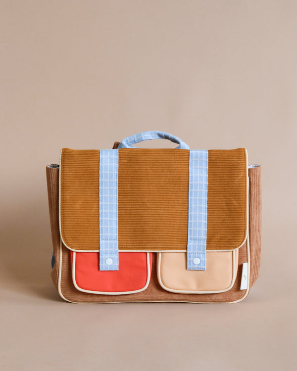A stylish Sticky Lemon School Bag | Farmhouse | Corduroy Harvest Moon with tan body, red front pocket, blue straps, and white detailing, displayed against a neutral backdrop.