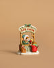 The Wee Forest Folk Tiny Collectible - Hot Cocoa Comin' Up! features a hand-sculpted mouse in a green hat at a hot cocoa stand, serving a cup to a reindeer in red scarf, with holly and snow accents on a beige background.