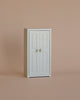 A small white cabinet with two doors and round knobs stands against a plain beige background, making it a perfect addition to your Maileg Bedroom Set for storing Maileg mouse accessories or complementing other Maileg mouse furniture.