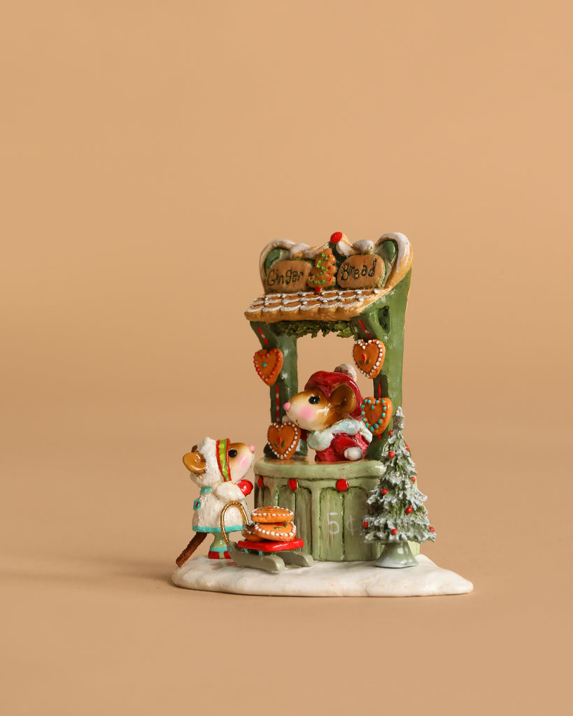The Wee Forest Folk Tiny Collectible - A Gingerbread Christmas features two mice miniatures at a green gingerbread stand with heart-shaped cookies and a snowy Christmas tree, set against a plain beige background.