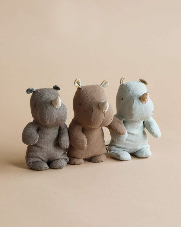 Three Small Maileg Rhino toys made from the softest fabric sitting against a plain background; a gray bear on the left, a brown bear in the middle, and a blue hippo on the right, all