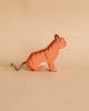The Ostheimer Handmade Wooden Safari Animals Set features a small, handcrafted wooden tiger figurine with painted orange and black stripes and a yarn tail, perfect for imaginative play, shown against a plain beige background.