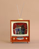 The Christmas Music TV With Nutcracker is a vintage-inspired light-up TV set with antennas that showcases a miniature scene featuring a decorated Christmas tree on a stage framed by red curtains, while playing whimsical Christmas melodies. Complete with knobs and buttons below the screen, it sits against a beige background—ideal for adding to your final sale collection.