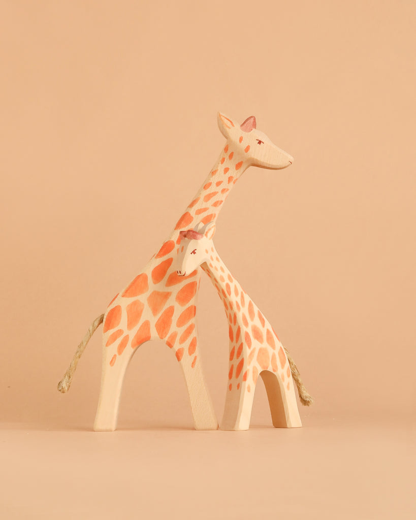 The Ostheimer Handmade Wooden Giraffe Set features two minimalist giraffe figurines—one large and one small—with charming orange spots on neutral wood backgrounds. Standing side by side to evoke the bond between parent and child, these sustainable, handcrafted toys bring timeless beauty and thoughtful craftsmanship to any collection.